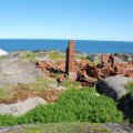 Самое настоящее пепелище. Это и был маяк. Судя по фотографиям в интернете он представлял собой обычный дом, но с пристроенной к нему невысокой башенкой. Видимо из-за утраты маяка остров со всеми постройками потерял свою значимость и был заброшен.Недалеко от маяка ещё одна избушка, к которой ведёт лестница.